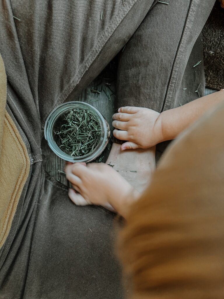 baby helping mother process rosemary