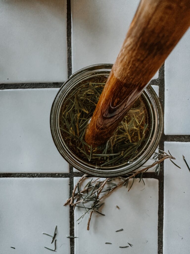 stirring rosemary infused oil to release bubbles